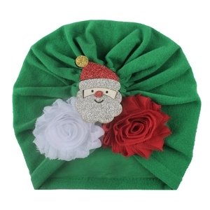 Detail view of baby Christmas turban hat with Santa charm and chiffon floral accents