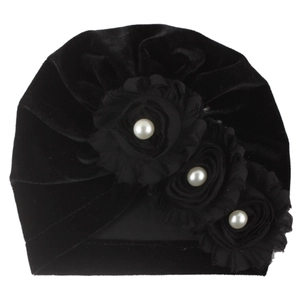 Detail of black velvet baby turban with mesh flowers and faux pearl embellishments