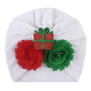 Detail of baby Christmas turban featuring red and green chiffon flowers with sequined gift box