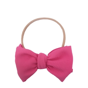 Pink waffle texture bow on nude nylon headband for infants and babies with soft fabric