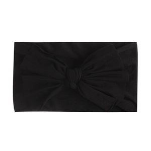 Detailed view of the soft black nylon headband featuring a large fabric bow decoration
