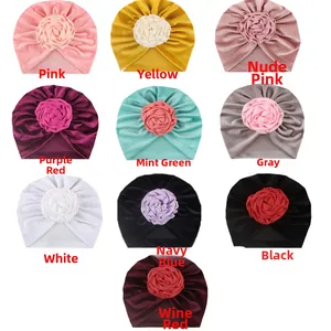 Vue détaillée de bonnets turban en velours pour bébé avec grandes roses en tissu décoratives