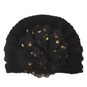 Close-up of baby turban hat featuring chunky knit and large chiffon gold foil flower