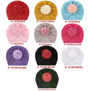Vista piatta di dieci cappelli colorati per neonati con fiori e fodera in pile morbido