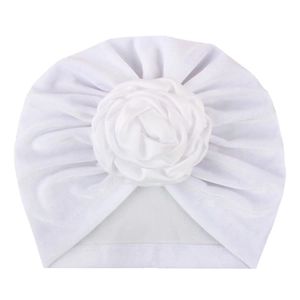 Détail d'un bonnet turban blanc pour bébé avec une grande fleur de rose en tissu 3D