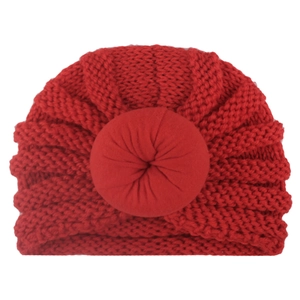 Detailed close-up of a red knit baby donut hat with thick yarn and cozy texture