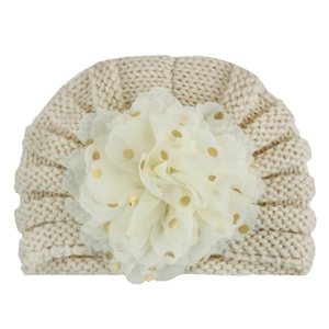 Knitted baby turban hat in cream white with a large gold polka dot floral decoration