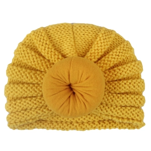 Ginger yellow knitted baby turban hat with a thick donut knot on a clean white background