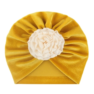 Bonnet turban bébé en velours jaune gingembre avec fleur en tissu crème sur fond blanc