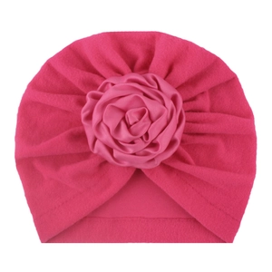 Dettaglio cappello in pile rosa per neonato con grande fiore di raso multistrato