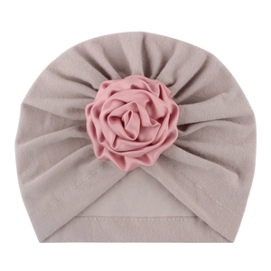 Dettaglio del cappello a turbante per neonato in maglia morbida con grande rosa di raso