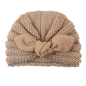 Detailed knit texture and large bow on light beige baby winter turban hat