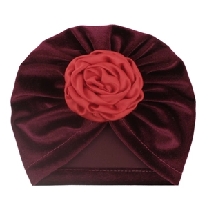 Détail du bonnet turban pour bébé en velours doré avec une grande fleur de rose en satin