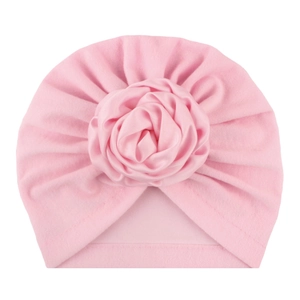 Dettaglio del cappello a turbante rosa per neonati con grande rosa di raso e tessuto pieghettato