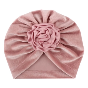 Bonnet turban rose en velours pour bébé avec une grande rose décorative en tissu sur fond blanc