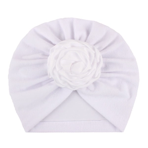 Dettaglio del turbante bianco per neonato con una grande decorazione di rosa in raso