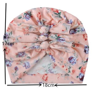 Dettaglio del cappello a turbante rosa per neonati con fiori, misure 17x18cm e fiocco