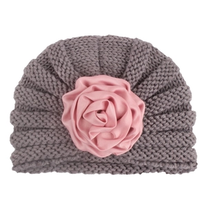 Close-up of baby turban hat featuring a grey knit texture and pink satin rose flower