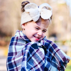 Détail du bandeau en maille blanche avec nœud et châle à carreaux doux pour filles