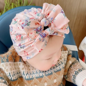 Dettaglio cappello a turbante per neonati con tre fiocchi e tessuto a maglia morbido
