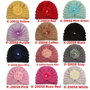 Vue détaillée de 12 coloris de bonnets bébé en tricot avec fleurs en mousseline et perles