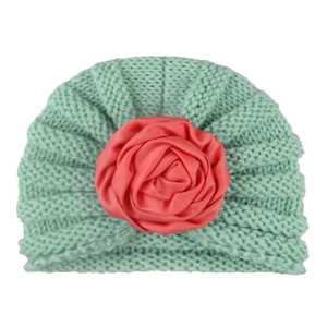 Close-up of knit turban hat for babies with pink satin rose and green weave texture