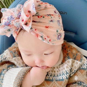 Dettaglio del cappello a turbante floreale per neonati in rosa chiaro con doppio fiocco