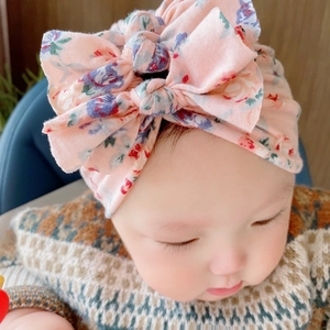 Dettaglio del turbante per neonato floreale rosa con decorazione a doppio fiocco