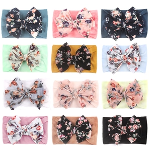 Lot de 12 bandeaux en nylon à fleurs pour bébés présentés dans une grille 4x3
