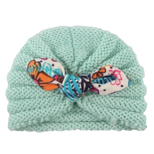 Mint green baby knit turban hat featuring a large colorful floral print bow for infants