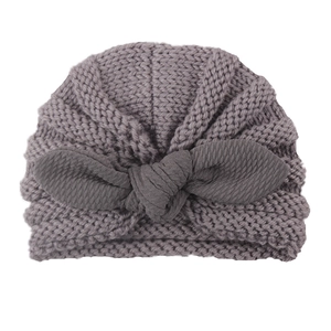Winter knitted baby beanie with large bow decoration in medium grey color for toddlers
