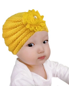 Détail du bonnet turban tricoté pour bébé jaune avec fleur en mousseline et perle