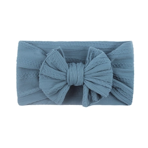 Détail du bandeau bébé bleu avec tissu gaufré doux et un grand nœud décoratif centré