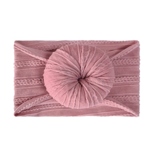 Close-up of pink knit baby headband featuring a soft donut knot and braided texture