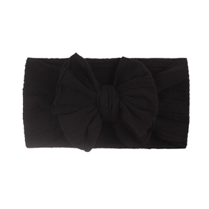 Détail d'un bandeau noir doux en maille côtelée pour bébé avec un joli nœud en tissu