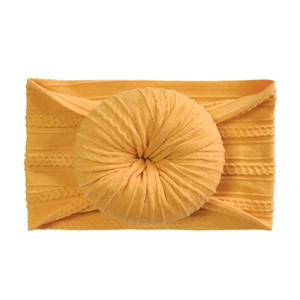 Detailed close-up of orange ribbed knit baby headband with a donut knot design