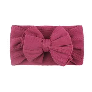 Bandeau bébé en maille rose foncé avec un grand nœud et un motif torsadé doux et souple