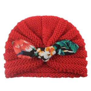 Red knit baby turban hat featuring a tropical floral print bow with warm thick texture