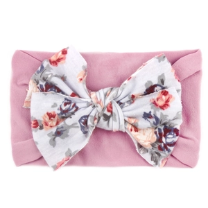 Détail du bandeau rose élastique pour bébé avec un grand nœud à motif de roses