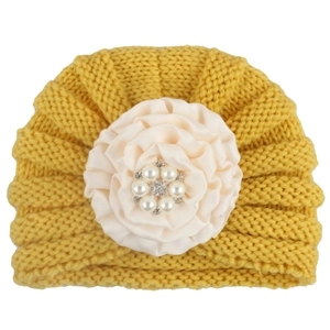 Bonnet bébé en tricot jaune avec fleur en tissu crème ornée de perles et strass