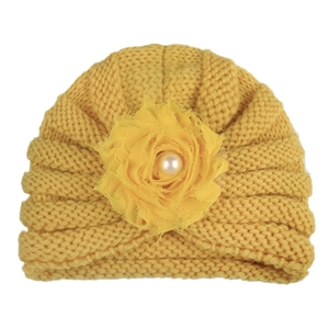 Bonnet tricoté jaune pour bébé avec fleur en mousseline et perle sur fond blanc