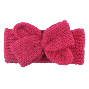 Gros plan d'un bandeau bébé en maille rose rouge avec un grand nœud papillon épais