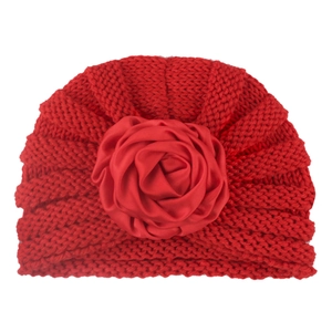 Bright red knitted baby turban hat featuring a large soft decorative fabric rose