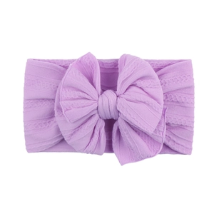 Gros plan d'un bandeau bébé en maille violette avec un grand nœud décoratif