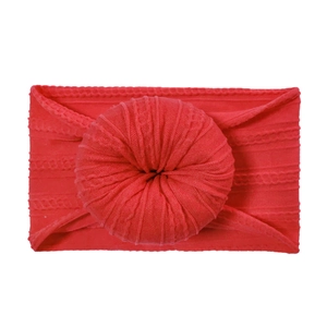 Detail of red cable knit baby headband featuring a soft ribbed donut knot on white background