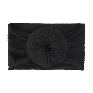 Detail of soft black cable knit infant headband featuring a large donut knot decoration
