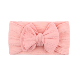 Détail du bandeau bébé en jacquard de nylon rose clair doux avec un grand nœud