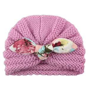 Lilac pink knit baby beanie with a colorful floral print bow and thick weave texture