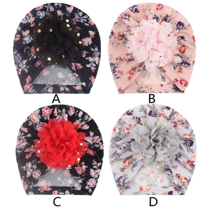Detail view of four floral baby turbans with large 3D mesh flowers and gold sequins
