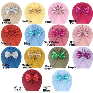 Flat lay matrix of baby turban hats with sequin bows in 14 varied vibrant colors